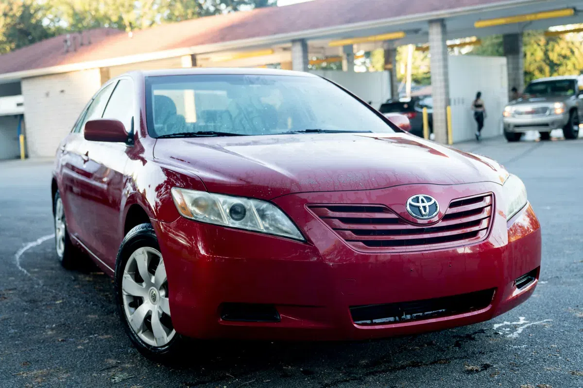 Red Toyota Camry viewed from the front three-quarter angle